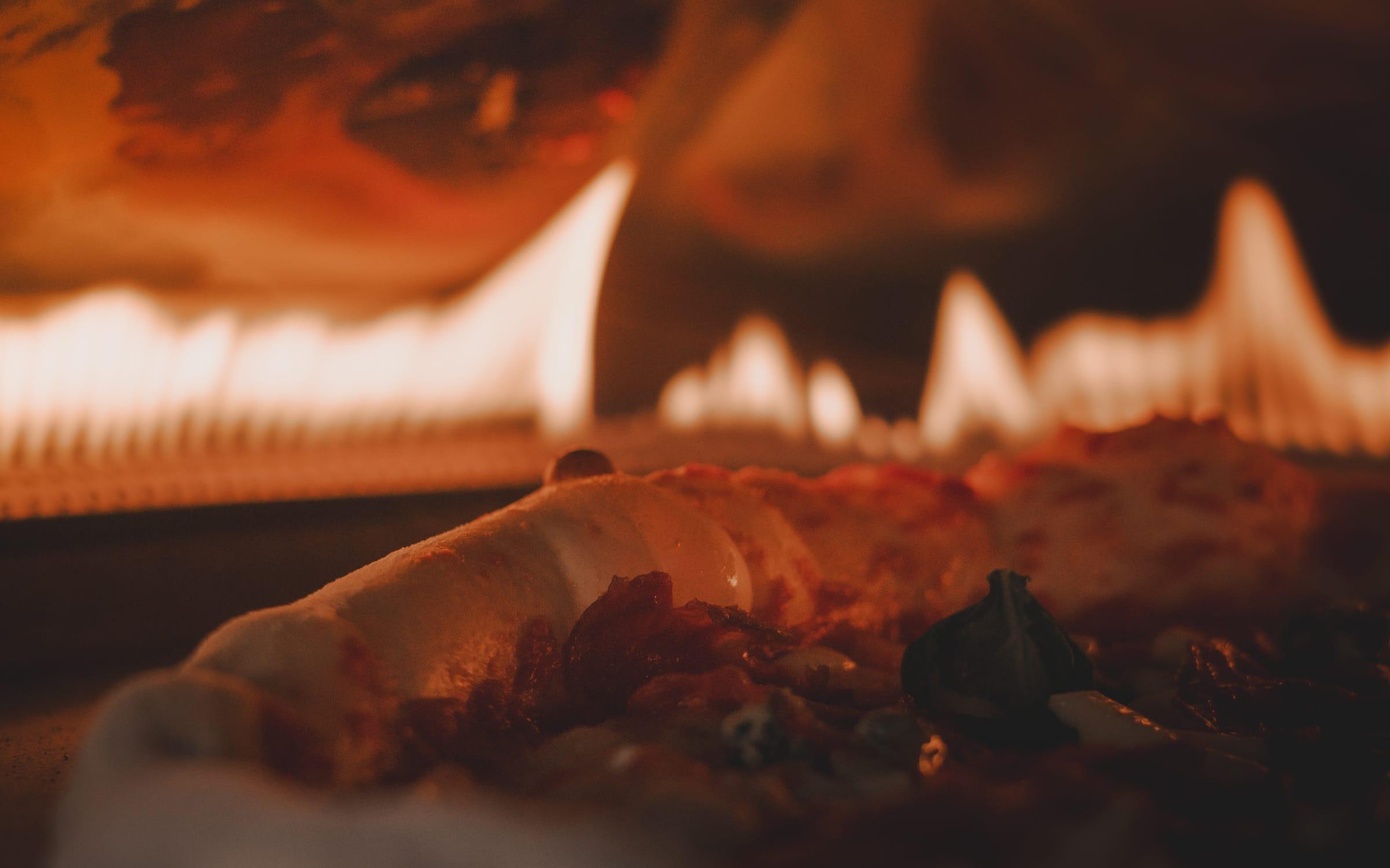 Pizza sül a lángoló kemencében