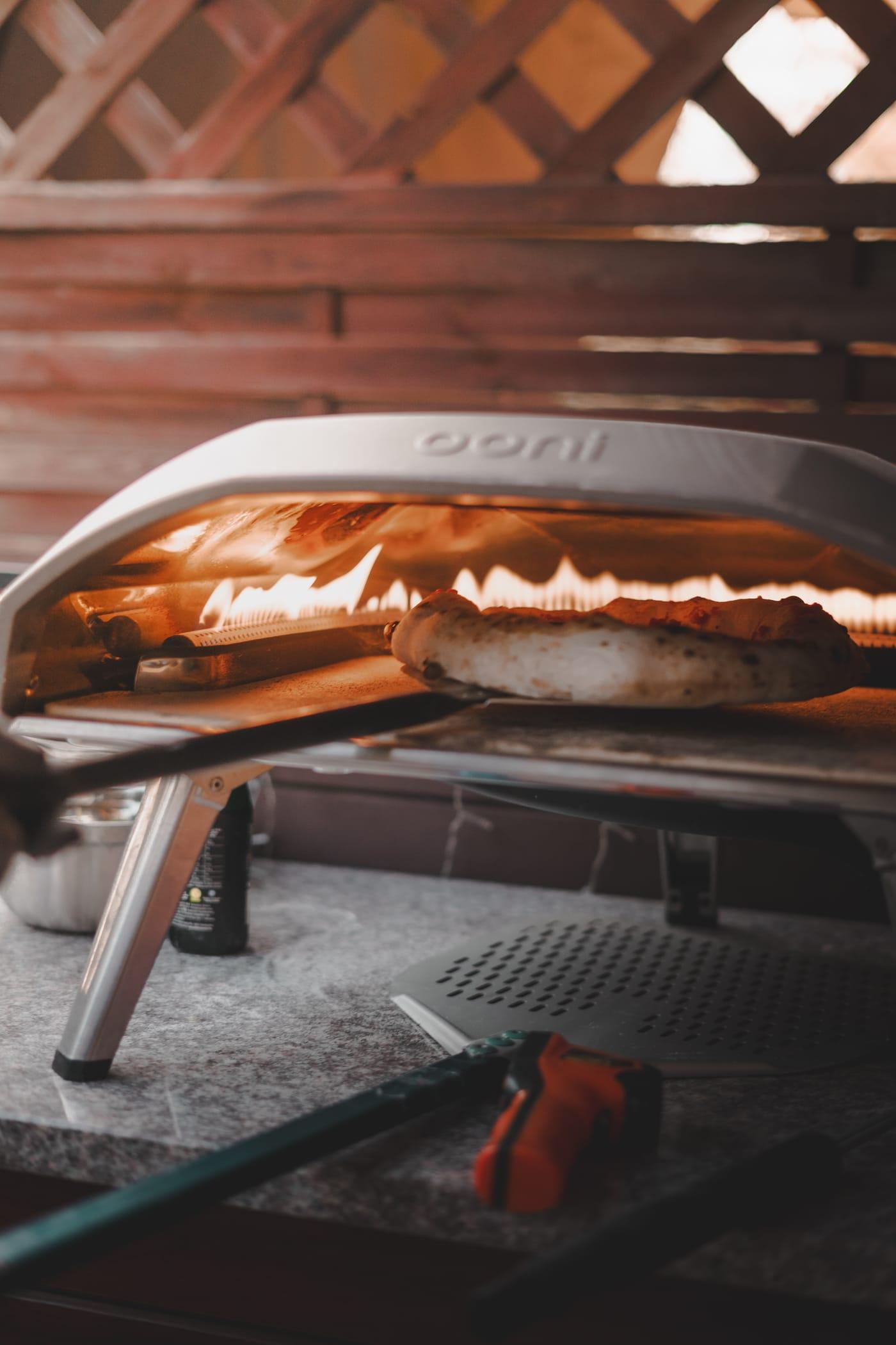 Pizza a kemencében, mögötte lángok