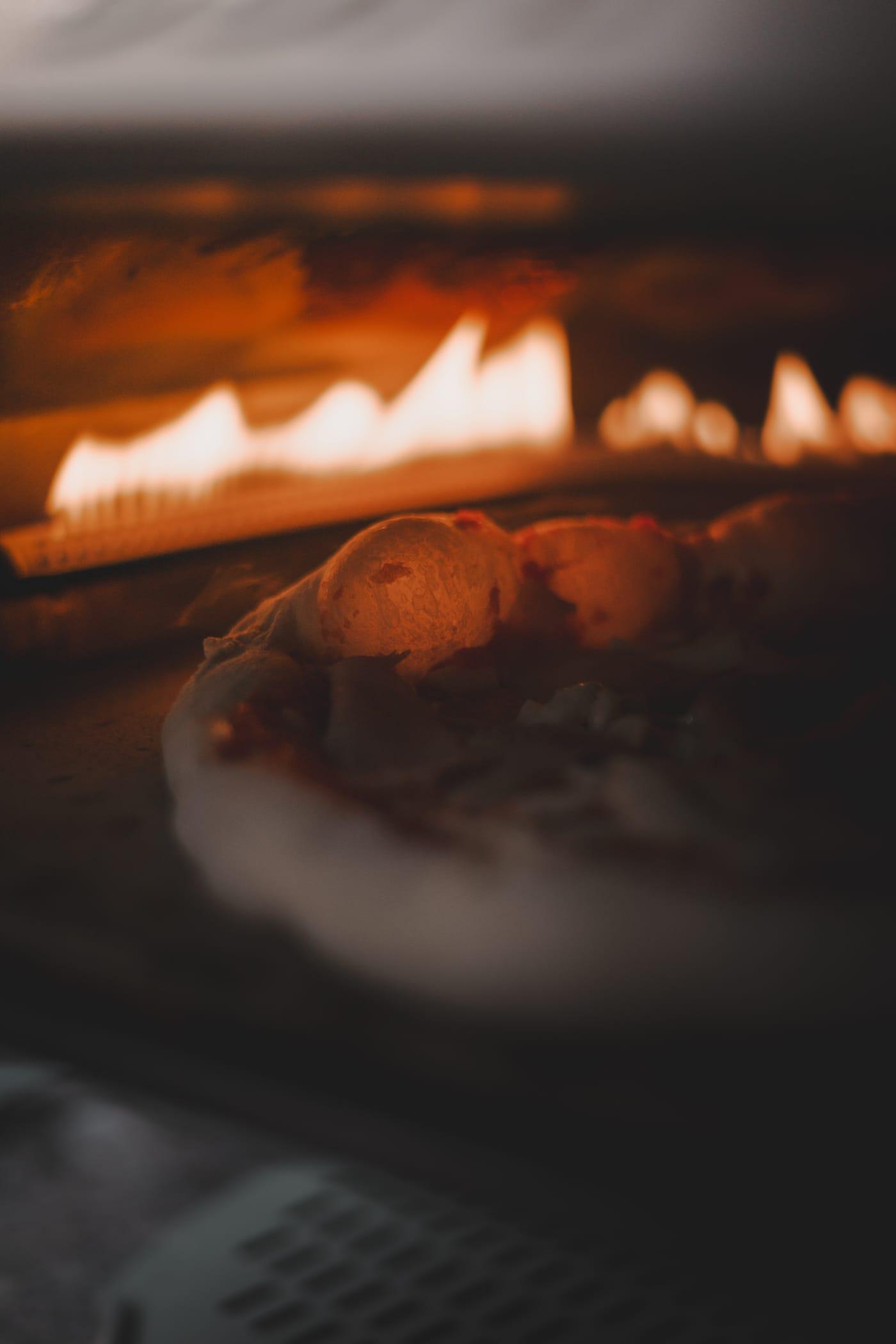 Pizza sül a kemence lángjai alatt